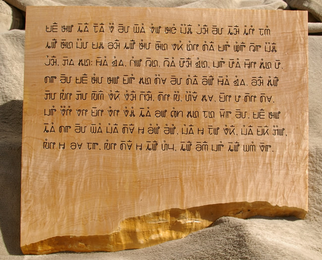 An text in Hmong in the Pahawh Hmong script carved into a wooden block