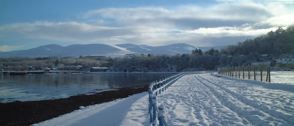 Golwg o Fae Hirael a'r Carneddau efo eira arnynt